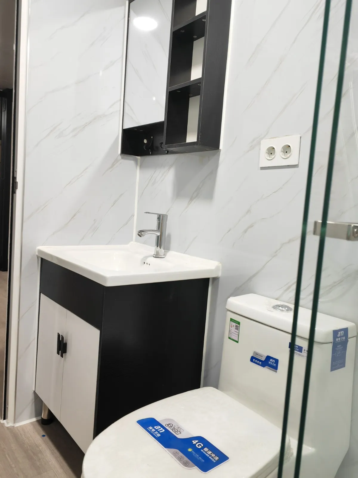 Mueble de lavabo negro con espejo e inodoro cerámico en el baño de la Morvedre