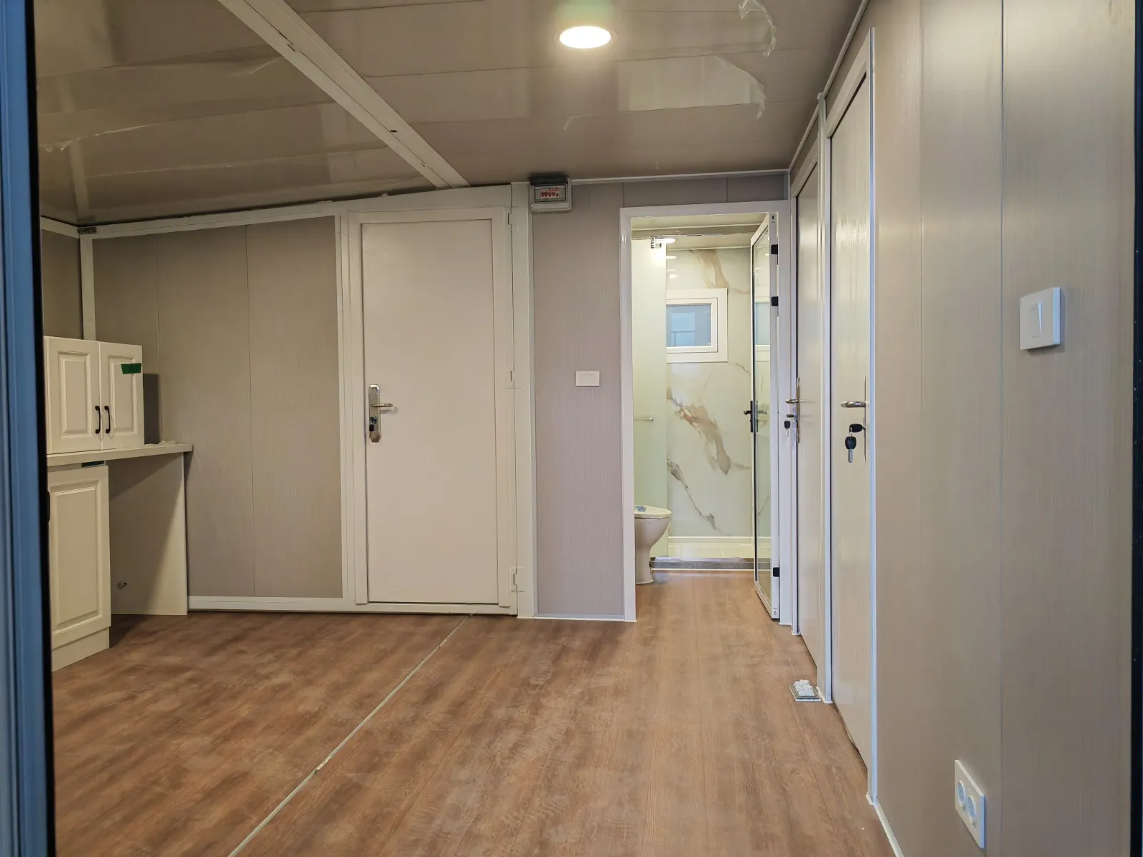 Salón de la Canet con paneles beige de veta de madera y suelo marrón oscuro